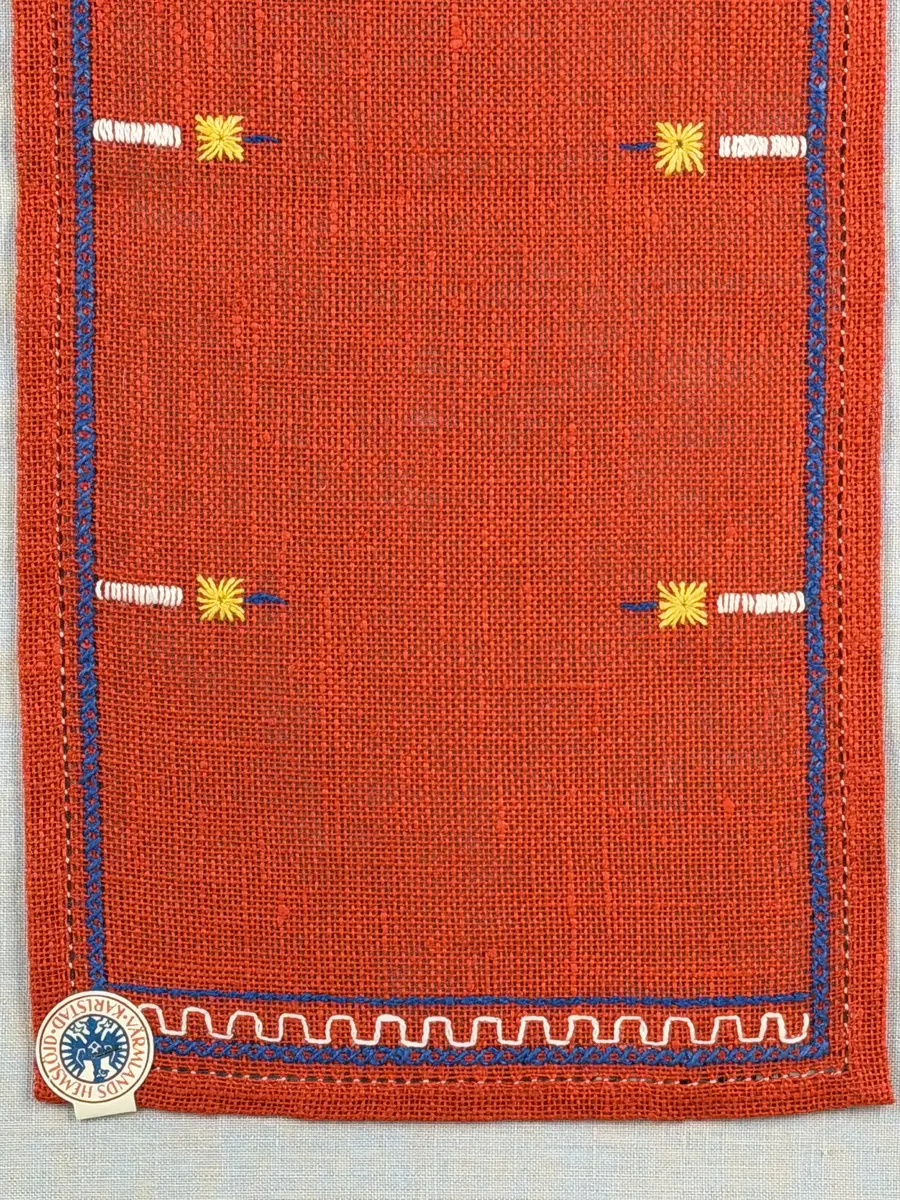 Jullöpare gjord av linneväv med 7tr/cm i tuskaft och broderi utfört med lingarn i stjälksöm, rutsöm, plattsöm samt korsstygn. 
Löparen är inramad med en korsstygns rad och kanterna har 9mm breda fållar runt om fastsydda med en halv hålsöm plus sneda hörn, vilka är sydda med kaststygn. 