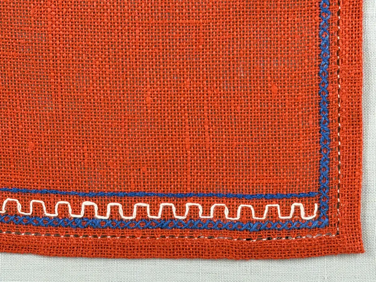 Jullöpare gjord av linneväv med 7tr/cm i tuskaft och broderi utfört med lingarn i stjälksöm, rutsöm, plattsöm samt korsstygn. 
Löparen är inramad med en korsstygns rad och kanterna har 9mm breda fållar runt om fastsydda med en halv hålsöm plus sneda hörn, vilka är sydda med kaststygn. 