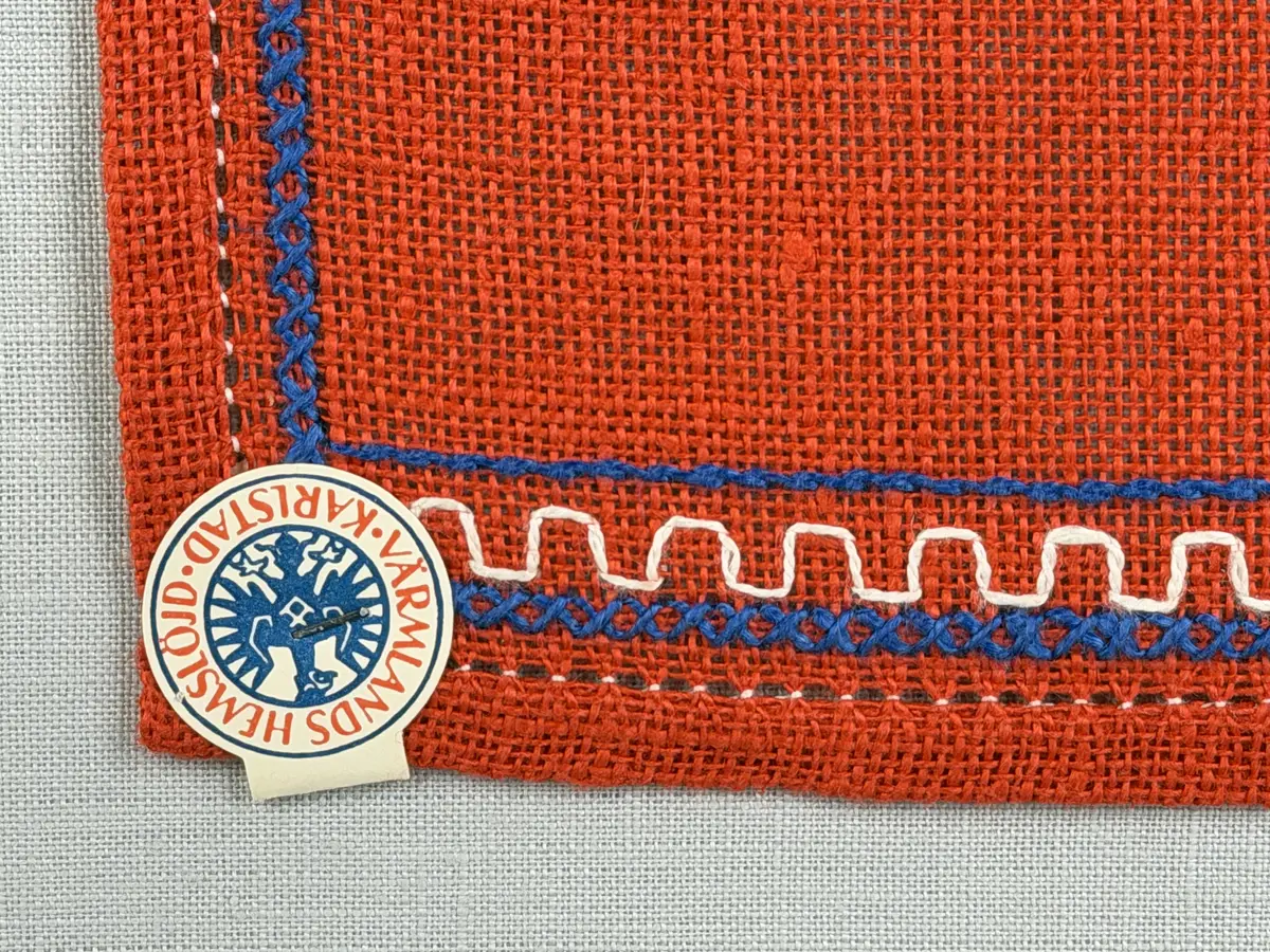 Jullöpare gjord av linneväv med 7tr/cm i tuskaft och broderi utfört med lingarn i stjälksöm, rutsöm, plattsöm samt korsstygn. 
Löparen är inramad med en korsstygns rad och kanterna har 9mm breda fållar runt om fastsydda med en halv hålsöm plus sneda hörn, vilka är sydda med kaststygn. 