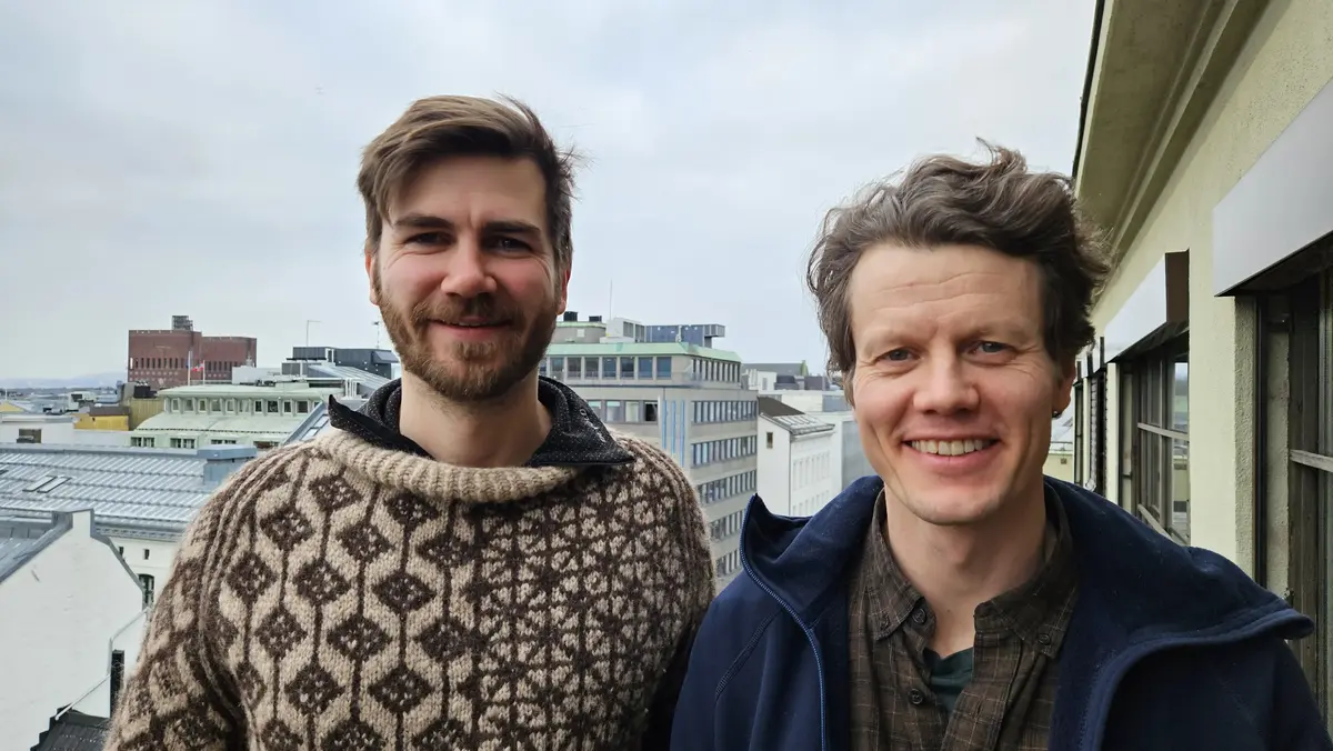 to menn står på ein terrasse med utsikt over Oslo