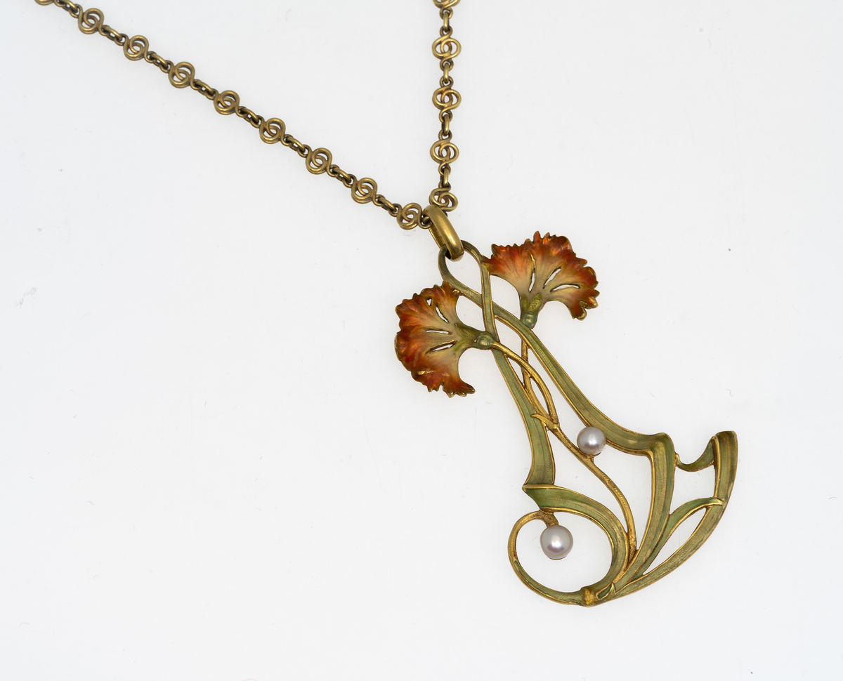 Halssmykke i gull og emalje. Gjennombrutt kjede med emaljerte nelikker og slyngende linjeføringer med perler, samt leddet kjede i gull.