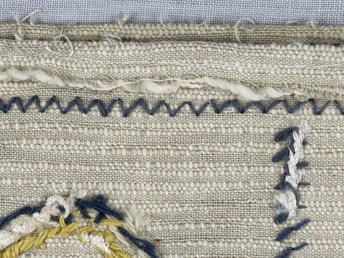 Kuddvar, gjord av tuskaftsväv i bomull och cottolin, som är dekorerad på framsidan med broderi utfört med ullgarn och splendolin i stjälksöm, kedjesöm, bottensöm, läggsöm, trädsöm, knutar samt ryaknutar. Kuddvaret är hopsytt med raksöm, därefter ett varv med stjälksöm cirka 1cm in från ytterkanten på kuddvarets rätsida.