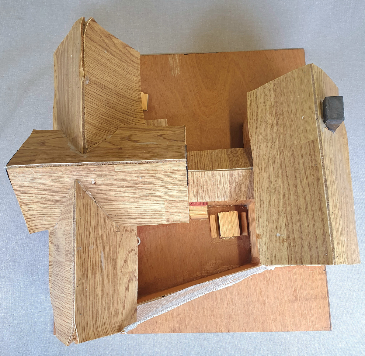 Målestokkmodell av Molde fengsel limt til en treplate. Bygget av finerplater, fyrstikker, papp, vinylbelegg, plast og tekstil. I vinduene i det fremste bygget er det bilder av forskjellige folk, blant annet hijackere tilknyttet 9/11 som var de eneste bildene med navn under.