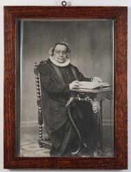 En prest (Diderik Hegermann Brochmann) sitter ved et lite  b