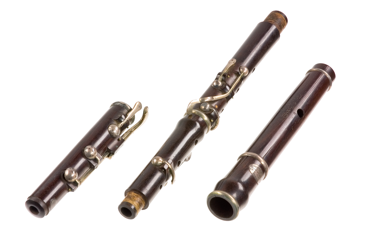 Tvärflöjt i ebenholts med silverringar. Nedersta ringen saknas. 5 delar. Konisk form. Sprickor i munstycke och päron. Stämpel på oval silverplatta på päronet. C-fot. 8 klaffar i silver med bocklagring och kulformade plattor. 