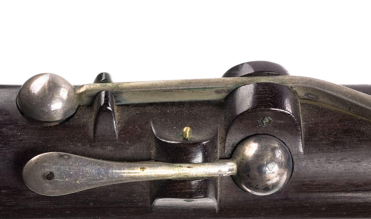 Tvärflöjt i ebenholts med silverringar. Nedersta ringen saknas. 5 delar. Konisk form. Sprickor i munstycke och päron. Stämpel på oval silverplatta på päronet. C-fot. 8 klaffar i silver med bocklagring och kulformade plattor. 