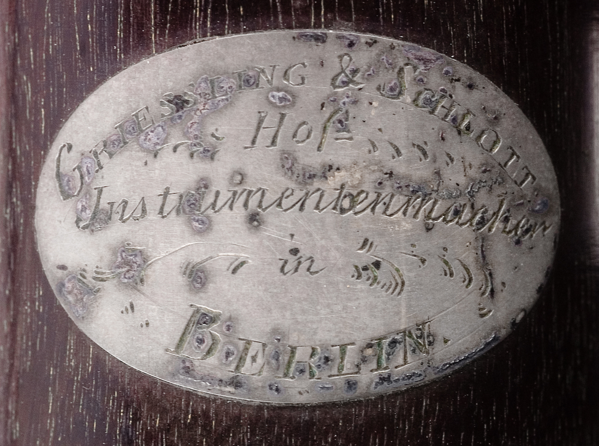 Tvärflöjt i ebenholts med silverringar. Nedersta ringen saknas. 5 delar. Konisk form. Sprickor i munstycke och päron. Stämpel på oval silverplatta på päronet. C-fot. 8 klaffar i silver med bocklagring och kulformade plattor. 