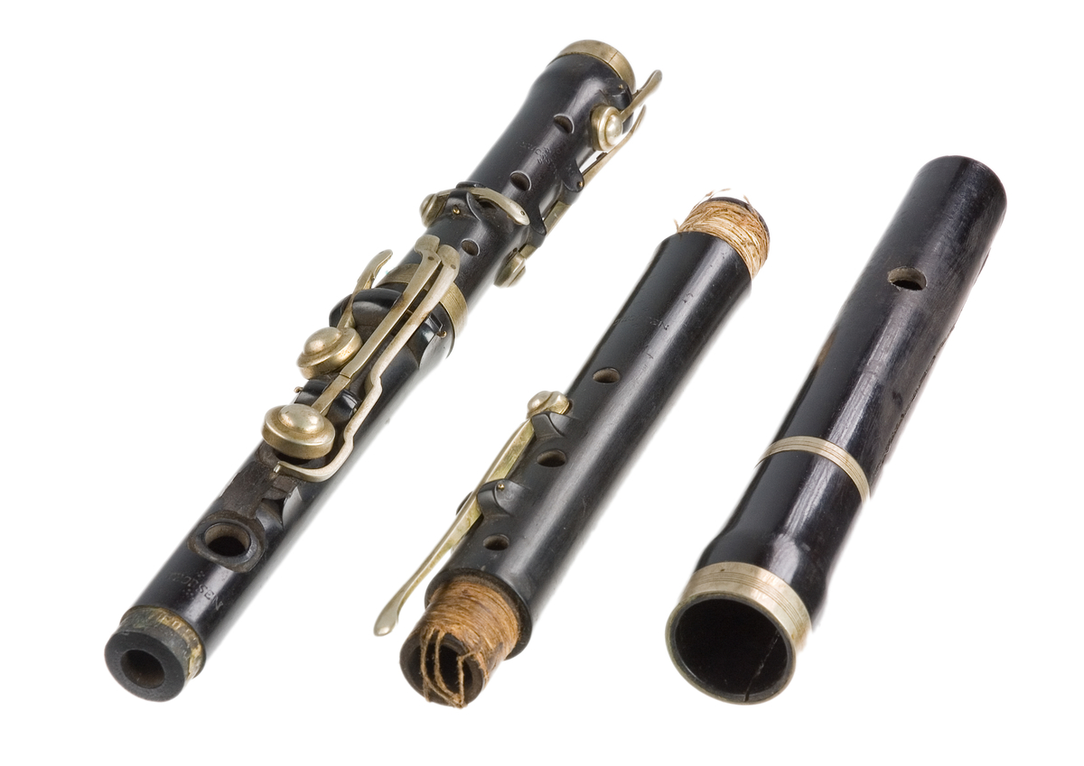 Tvärflöjt i ebenholts med ringar av silver. Nedersta ringen saknas. 5 delar. Sprickor i munstycke och päron. C-fot. 8 klaffar med bocklagring och tjocka runda plattor med kulformade toppar. Delar av lägsta klaffen och dess lagring saknas.