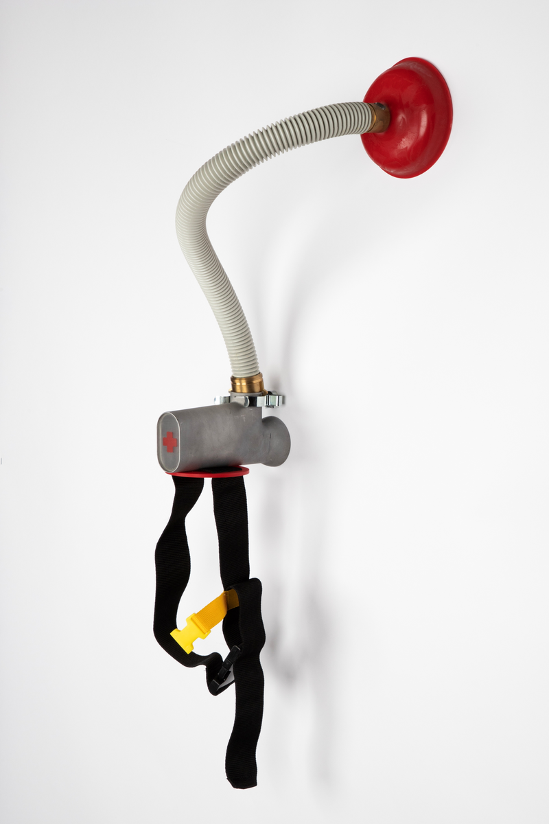 Smykke som skal bæres på ryggen, satt sammen av readymades. Består av et belte med spenner som skal festes rundt midjen. Til beltet kan det kobles en slange med sugekopp.