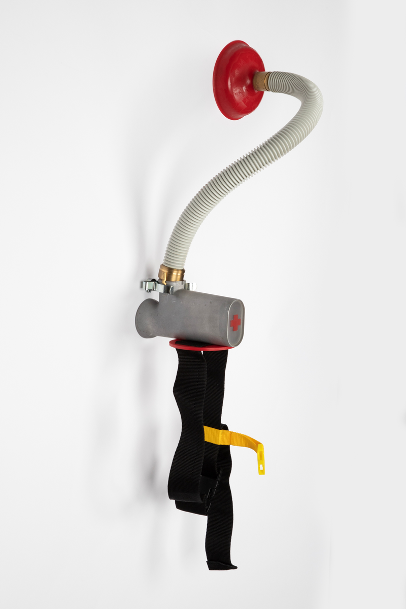 Smykke som skal bæres på ryggen, satt sammen av readymades. Består av et belte med spenner som skal festes rundt midjen. Til beltet kan det kobles en slange med sugekopp.