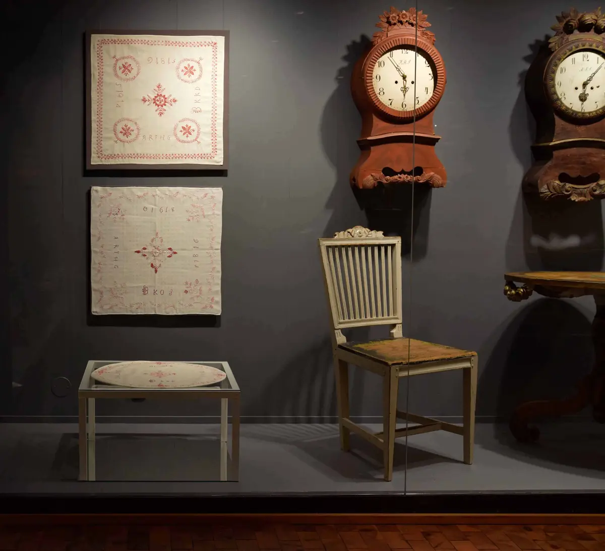 Utställnignsmonter från Händers verk; snidade väggur, möbler samt broderade dukar.