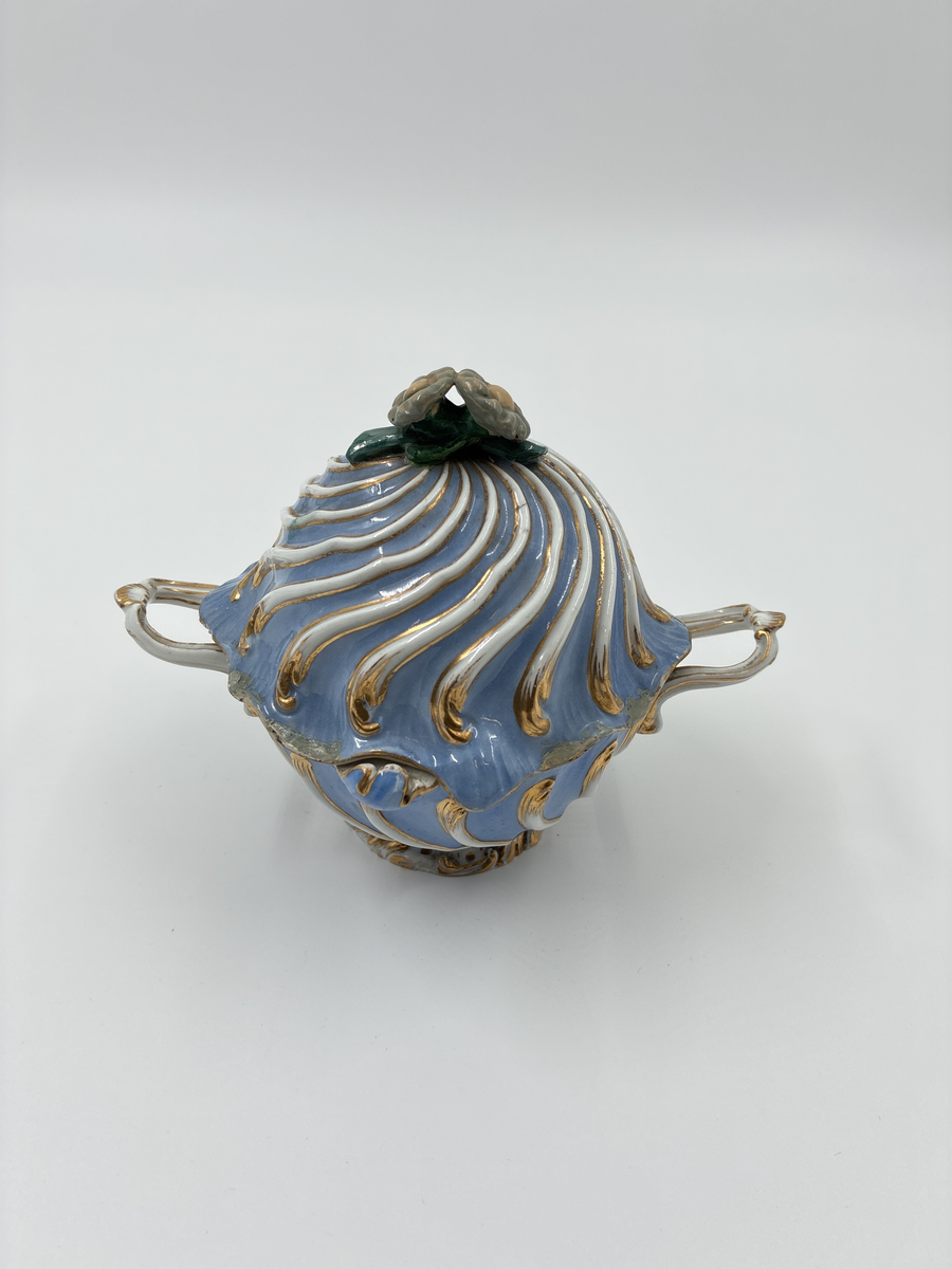 Bonbonjär med två handtag samt lock dekorerad med två blommor. Blåglaserat porslin med gulddekor. Från Meissen, Tyskland.