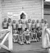 Simningen, 16/8 1942. 
Foto av en barngrupp med ledare, framför badhuset på Evedal.