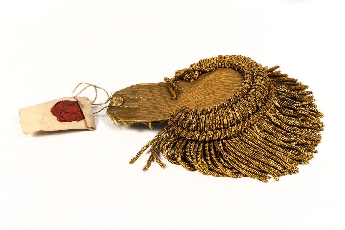 Epåletter M/1844. Klaff av guldtyg med smala buljoner och liten ankarknapp. Ofodrade.