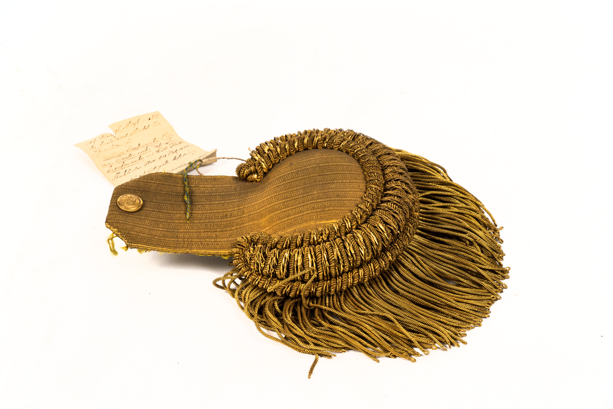 Epåletter M/1844. Klaff av guldtyg av guldtyg med trådsmala buljoner av guld samt liten ankarknapp. Ofodrad.