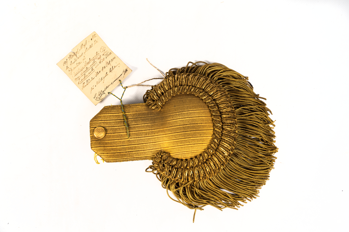 Epåletter M/1844. Klaff av guldtyg av guldtyg med trådsmala buljoner av guld samt liten ankarknapp. Ofodrad.