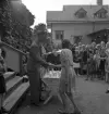 Simningen, 16/8 1942. 
Prisutdelning på Evedal. En flicka i blommig klänning får pris.