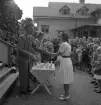 Simningen, 16/8 1942. 
Prisutdelning på Evedal. En flicka i ljus klänning får en liten 
bägare i pris.