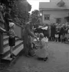 Simningen, 16/8 1942. 
Prisutdelning på Evedal. En flicka i rutig klänning får en liten 
bägare i pris.