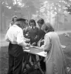 Orientering, 27/9 1942. 
En grupp ungdomar studerar underlag för orientering på ett bord.