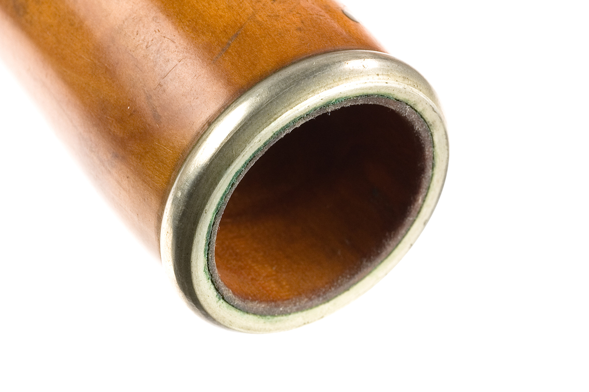 Tvärflöjt i buxbom med silverringar. 5 delar. C-fot. Kvadratiskt anblåsningshål. Tydliga märken efter användning vid anblåsnings- och fingerhål. 10 klaffar med kullagring, fästa i fastskruvade plattor. Klaffarnas plattor är runda. Klaffhålen har monterade metallrör.