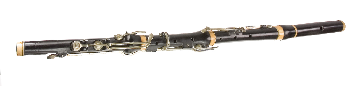 Tvärflöjt i ebenholts med ringar i elfenben. 5 delar. H-fot. Sprickor i munstycke och päron. 10 klaffar med bock- och vulstlagring. Klaffarna har runda, tämligen tjocka, plattor med en rundad upphöjning i mitten.