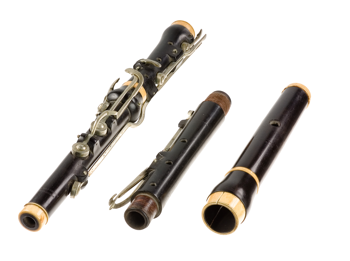 Tvärflöjt i ebenholts med ringar i elfenben. 5 delar. H-fot. Sprickor i munstycke och päron. 10 klaffar med bock- och vulstlagring. Klaffarna har runda, tämligen tjocka, plattor med en rundad upphöjning i mitten.