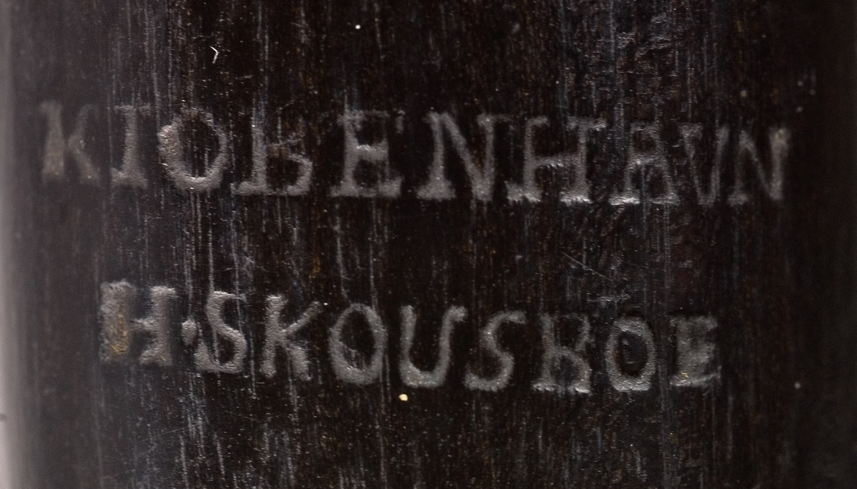 Tvärflöjt i ebenholts med ringar i elfenben. 5 delar. H-fot. Sprickor i munstycke och päron. 10 klaffar med bock- och vulstlagring. Klaffarna har runda, tämligen tjocka, plattor med en rundad upphöjning i mitten.