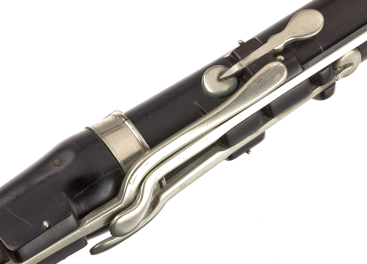 Tvärflöjt i ebenholts med silverringar. 5 delar. H-fot. Sprickor i munstycke och päron. 10 klaffar med bocklagring och kraftiga, runda plattor.