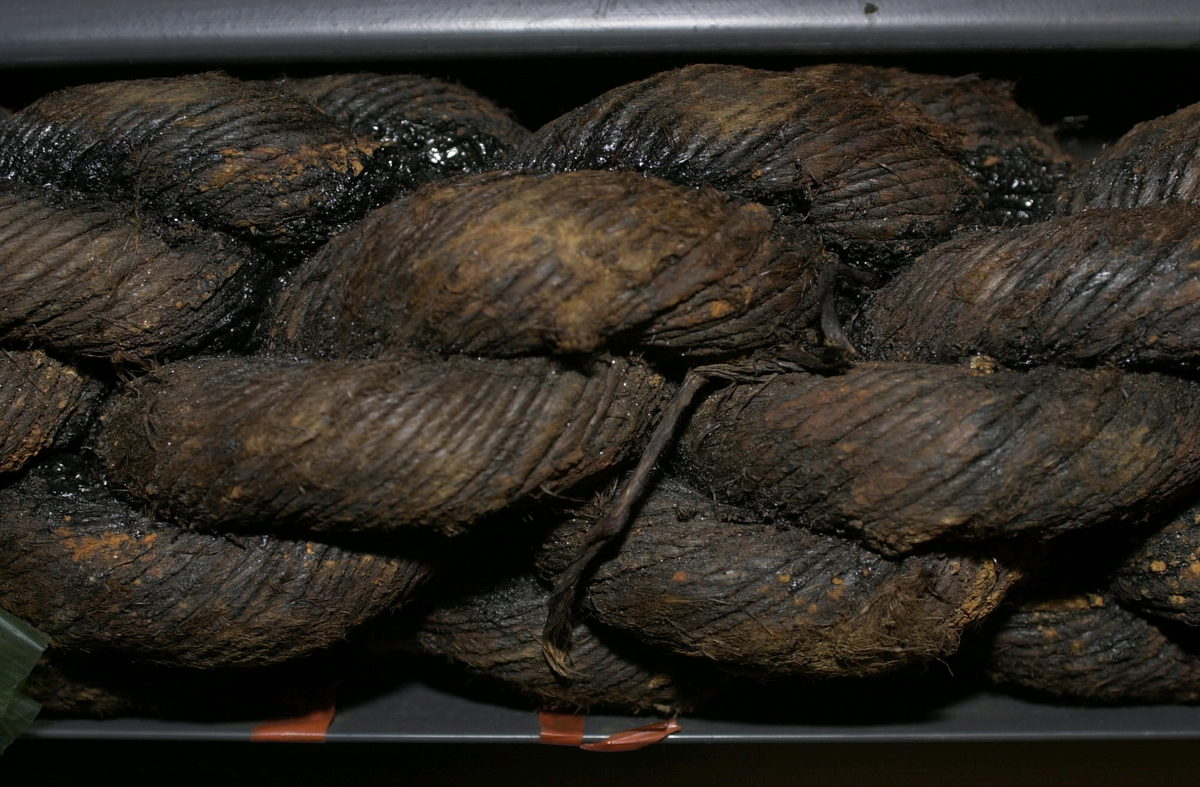 Tågvirke.
Del av grovt tågvirke till ankarkabeln.
S-slagen, tjärad del av ankarkabel, uppbyggd av tre Z-slagna trossar. Kabeln är skadad/fransig i ändarna och ligger i en skyddsränna av plast.