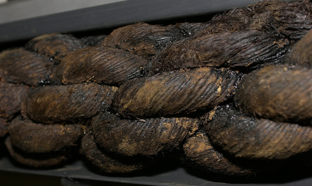 Tågvirke.
Del av grovt tågvirke till ankarkabeln.
S-slagen, tjärad del av ankarkabel, uppbyggd av tre Z-slagna trossar. Kabeln är skadad/fransig i ändarna och ligger i en skyddsränna av plast.