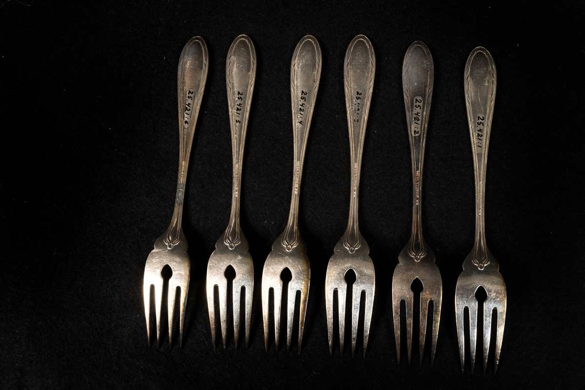 Sex stycken fiskgafflar med fyra taggar och ett hål i roten.