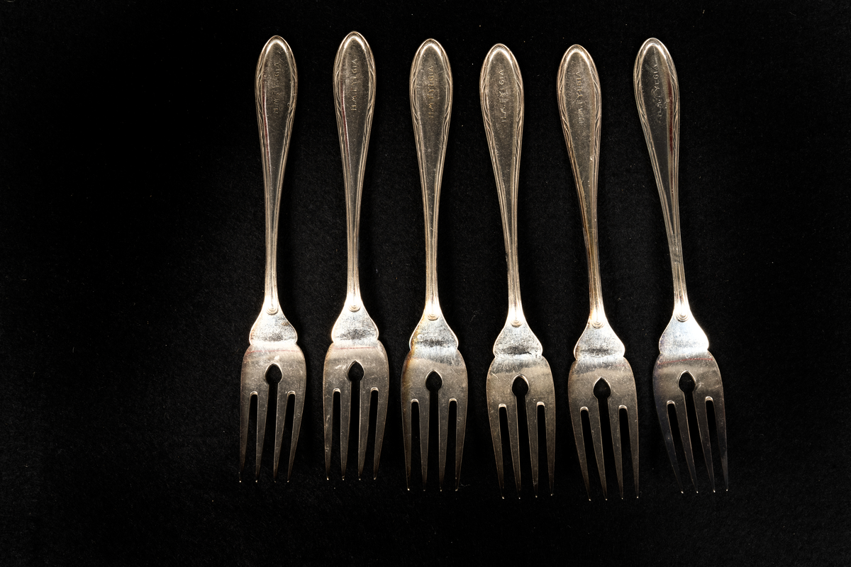 Sex stycken fiskgafflar med fyra taggar och ett hål i roten.
