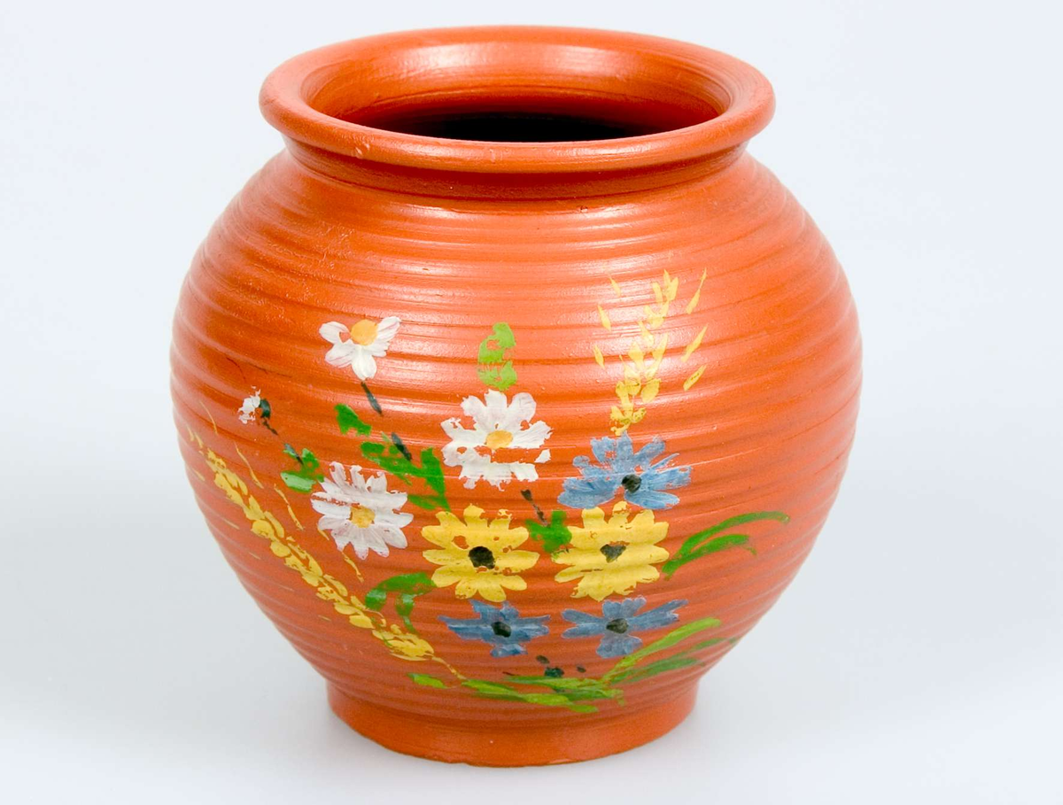 Liten kruka av rödbrunt lergods, drejad med handmålad polykrom blomdekor i gult, blått, grönt och vitt, låg fotring, stämplad: EKEBY 33 EL  8 ( ?)