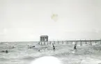 Människor som badar i havet och en badhytt längst ut på bryggan i Hornbaek, Danmark 1920.