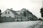 Byggnader som ligger efter en kullerstensgata i Torekov, Skåne 1922.