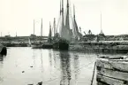 Vy över en hamn med segel- och fiskebåtar ligger förtöjda vid kajen vid Torekov, Skåne 1922.