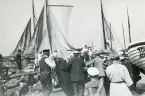 Torekov 1922. Bilden visar en hamn med förtöjda båtar och människor i rörelse, ser ut som de förmodligen skall sjösätta en båt.