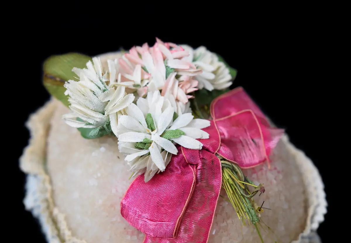 Ägg med rosa rosett och vita blommor ovanpå.