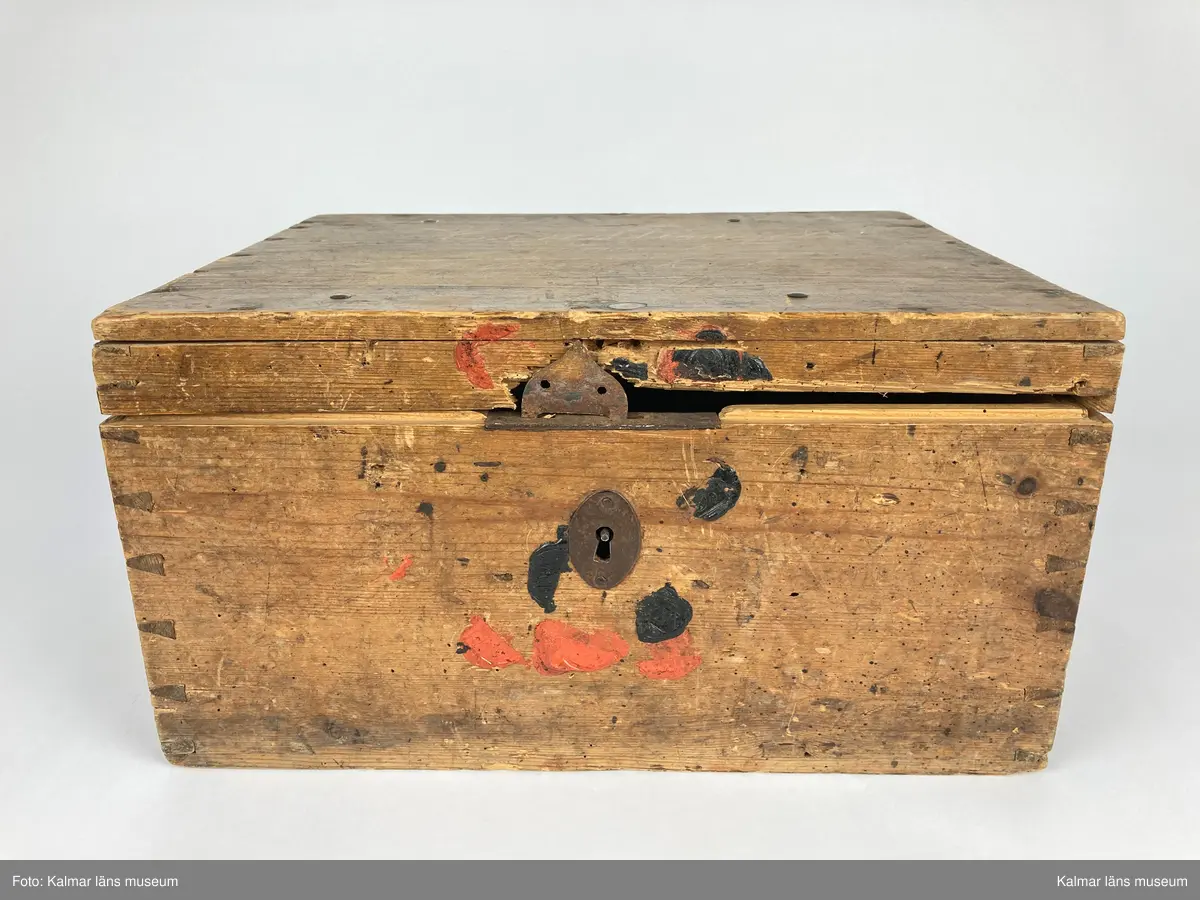 KLM 46971:1. Kista. Av trä med lås och beslag av järn samt på kortsidorna handtag av mässing varav det ena saknas. Kistan har rektangulär form och lock. Skriven text i rött på locket: Handlingar rörande läroverket. Ovanför text i svart: F W ... På undersidan av kistan målade siffror i svart. På fronten runt låset diverse lacksigill i svart och rött. Kistan har innehållit diverse handlingar rörande Kalmar högre allmänna läroverk. Väl använd.