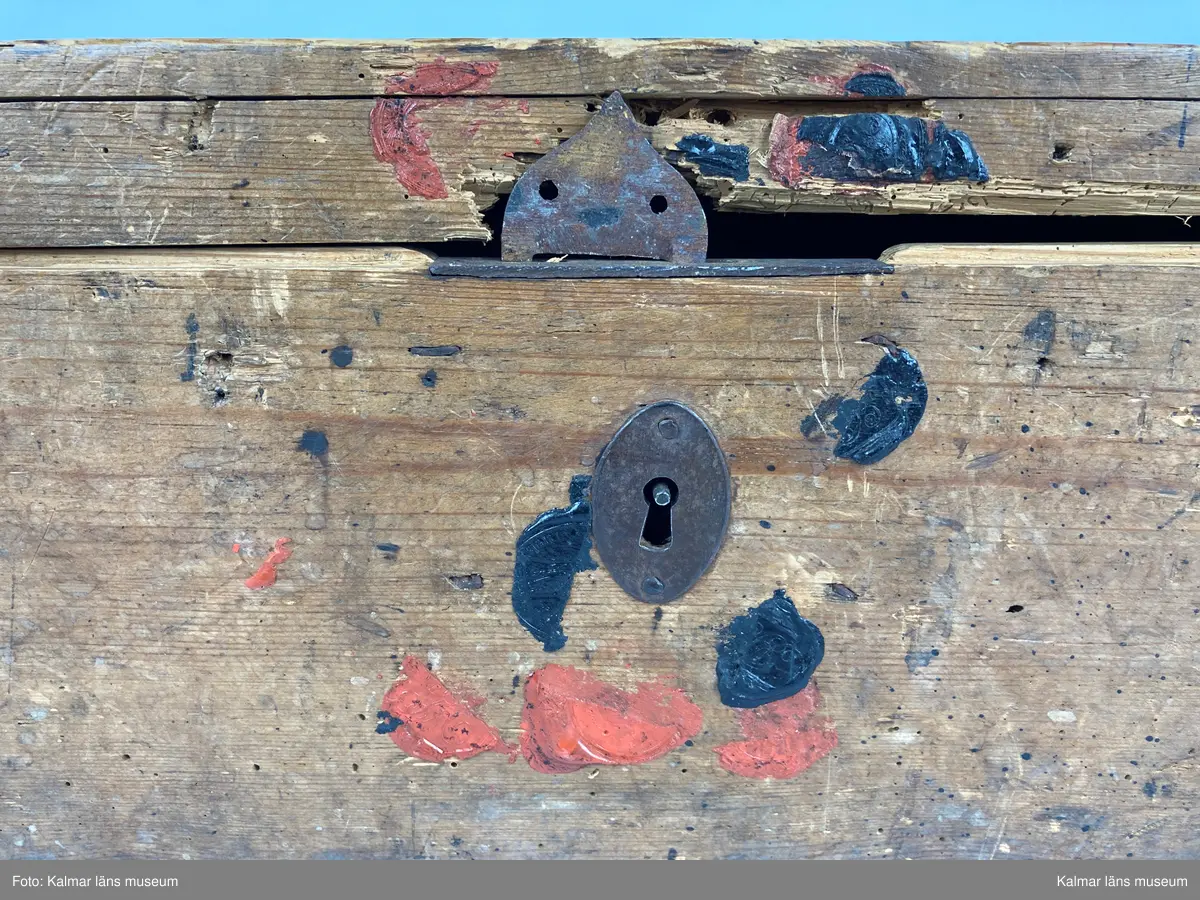 KLM 46971:1. Kista. Av trä med lås och beslag av järn samt på kortsidorna handtag av mässing varav det ena saknas. Kistan har rektangulär form och lock. Skriven text i rött på locket: Handlingar rörande läroverket. Ovanför text i svart: F W ... På undersidan av kistan målade siffror i svart. På fronten runt låset diverse lacksigill i svart och rött. Kistan har innehållit diverse handlingar rörande Kalmar högre allmänna läroverk. Väl använd.