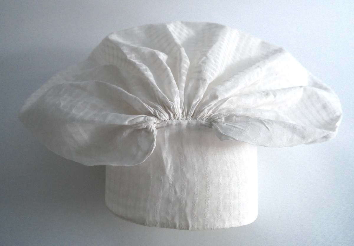 Konehue til folkedrakt frå Sogn. Sydd saman av to rektangulære bomullstykke. Det største stykket er rynka saman i sidene. Det andre stoffstykket er sydd på dei rynka sidene og dannar ein kvarding i framkant av hua. Der hjørnet i det store stykket er rynka saman, dannar det seg to "horn". Hua er trekt saman av ei snor, og er stiva.  