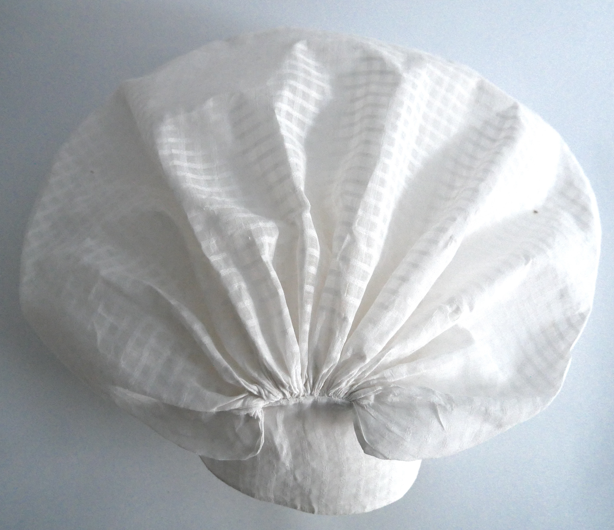 Konehue til folkedrakt frå Sogn. Sydd saman av to rektangulære bomullstykke. Det største stykket er rynka saman i sidene. Det andre stoffstykket er sydd på dei rynka sidene og dannar ein kvarding i framkant av hua. Der hjørnet i det store stykket er rynka saman, dannar det seg to "horn". Hua er trekt saman av ei snor, og er stiva.  