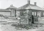 Arbete med örtagården i Gamla Linköping hösten 1956. I bakgrunden syns Landshövdingehuset och Skolmästaregården.