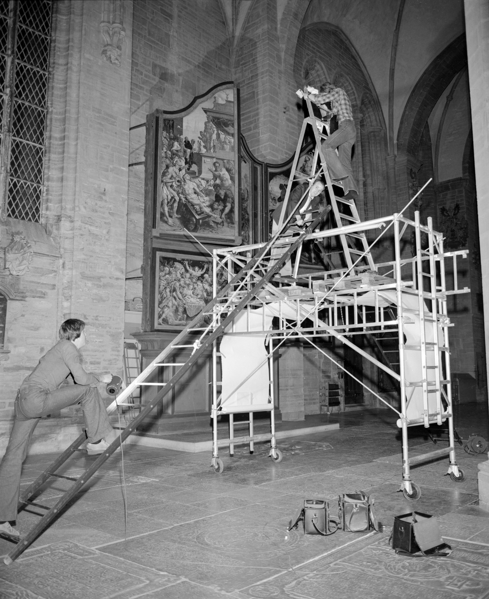 Komplicerad fotografering i Linköpings domkyrka när golvets gravhällar dokumenteras. Fotograf Arne Gustafsson med kollegorna Peter och Sören 1977.