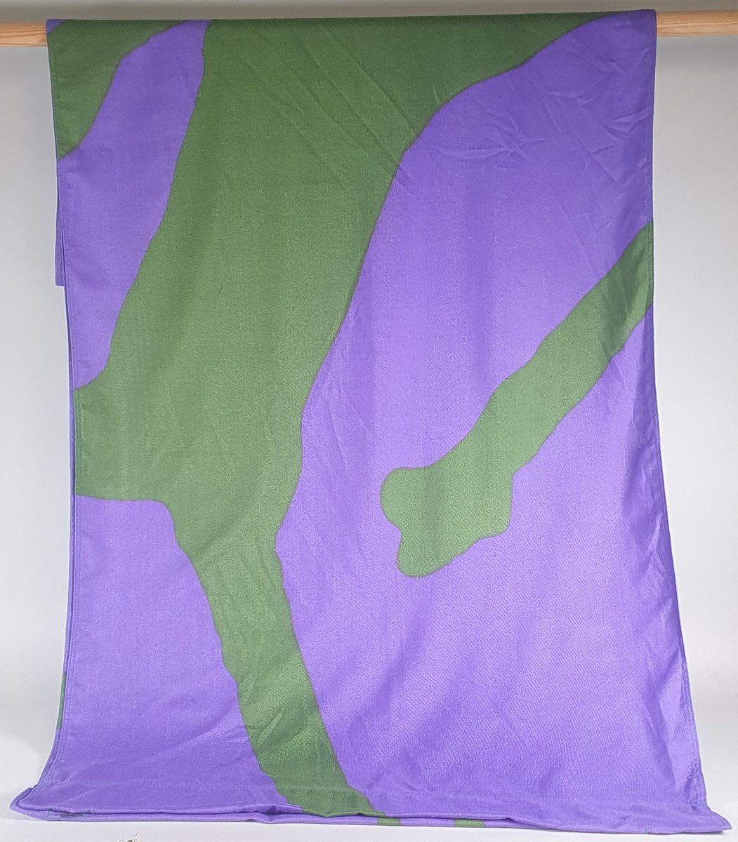 Grønt og lilla banner med deler av mønster fra piktogrammer - bob, kunstløp og fakkelmann. Krystallmønsteret inngikk i LOOCs designprogram.