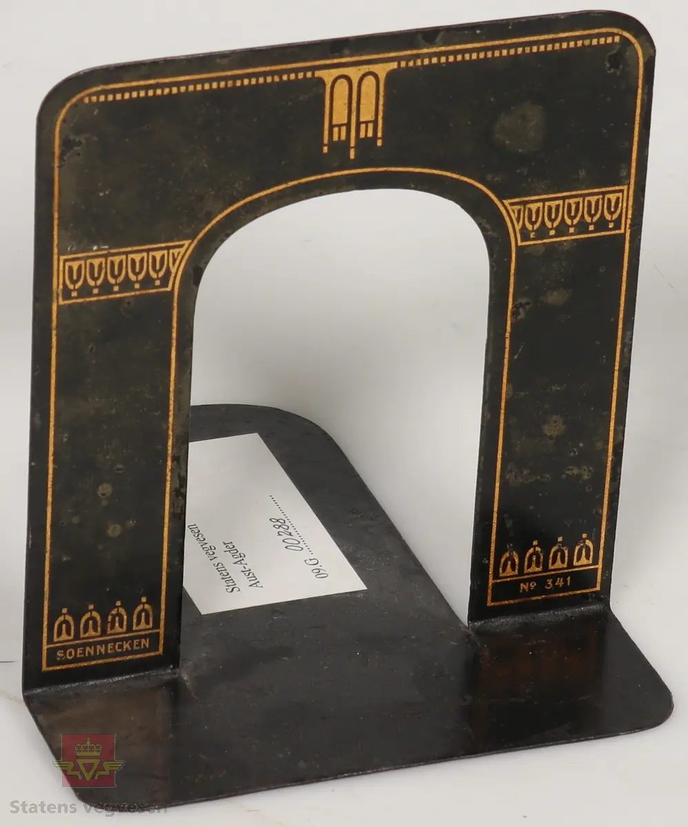 Sort solid tapeholder av metall. Sitter i en taperull av typen som må fuktes for å lime. Er merket med Kvikk II, Rasch&Co a/s- OSLO- Postboks 96. 
Mål: B 10cm, H 10cm, L 32cm.

Kart-måler av metall og glass, ligner på et lommeur med tallskive. Den har et lite hjul i enden som dras over kart for å måle avstander. Merket HC: (Harbo Colbjørnsen).
Mål: B 3cm, L 7cm,  Tykkelse 0,7cm, Diameter på glass Ø 3cm.

Bokstøtte av sortlakket metall med gull dekor.
Mål: B 13cm, H 14cm, D 15cm Tykkelse 0.1 cm.

Pengekasse av grønnlakkert metall med inndeling for sedler og mynter. 
Mål: B 30cm, D 18cm, H 4cm.

Skriveunderlag av metall med påsydd forsterkning av skinn  i hjørner. Beregnet for bruk i felt.
Mål: H 40cm, B 30cm, Tykkelse 2mm.

Skuffesorterer av lakkert lyst treverk med inndeling for sortering av småting som binders.
Mål B 33cm, D 23cm, H 3,5cm.

Tape-pen av gullfarget metall med 1/16" tape. Det er inngravert: Planavd. Sort etui med lokk og bruksanvisning inne i lokk. Er merket med Chart-pak,  Leeds, Massahusetts. 
Mål etui: L 14cm, B 9cm, H 4cm. Mål tape-pen: Diameter 7cm, Tykkelse 6mm.

Skriveunderlag av hvit papp som er forsterket i kanter og hjørner med brunt skinn. Har flekker av blekk.
Mål: H 43cm, B 62cm, Tykkelse 2mm.

Rundt lodd av metall med spiss i enden. For loddesnor.
Mål: L 8cm, Diameter 3cm.


