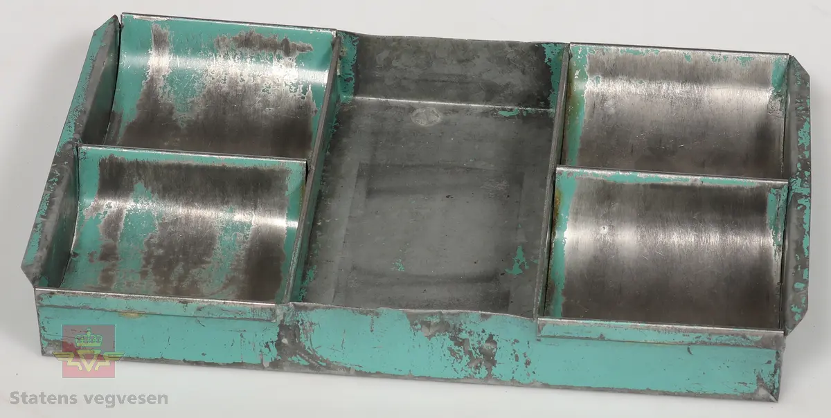 Sort solid tapeholder av metall. Sitter i en taperull av typen som må fuktes for å lime. Er merket med Kvikk II, Rasch&Co a/s- OSLO- Postboks 96. 
Mål: B 10cm, H 10cm, L 32cm.

Kart-måler av metall og glass, ligner på et lommeur med tallskive. Den har et lite hjul i enden som dras over kart for å måle avstander. Merket HC: (Harbo Colbjørnsen).
Mål: B 3cm, L 7cm,  Tykkelse 0,7cm, Diameter på glass Ø 3cm.

Bokstøtte av sortlakket metall med gull dekor.
Mål: B 13cm, H 14cm, D 15cm Tykkelse 0.1 cm.

Pengekasse av grønnlakkert metall med inndeling for sedler og mynter. 
Mål: B 30cm, D 18cm, H 4cm.

Skriveunderlag av metall med påsydd forsterkning av skinn  i hjørner. Beregnet for bruk i felt.
Mål: H 40cm, B 30cm, Tykkelse 2mm.

Skuffesorterer av lakkert lyst treverk med inndeling for sortering av småting som binders.
Mål B 33cm, D 23cm, H 3,5cm.

Tape-pen av gullfarget metall med 1/16" tape. Det er inngravert: Planavd. Sort etui med lokk og bruksanvisning inne i lokk. Er merket med Chart-pak,  Leeds, Massahusetts. 
Mål etui: L 14cm, B 9cm, H 4cm. Mål tape-pen: Diameter 7cm, Tykkelse 6mm.

Skriveunderlag av hvit papp som er forsterket i kanter og hjørner med brunt skinn. Har flekker av blekk.
Mål: H 43cm, B 62cm, Tykkelse 2mm.

Rundt lodd av metall med spiss i enden. For loddesnor.
Mål: L 8cm, Diameter 3cm.


