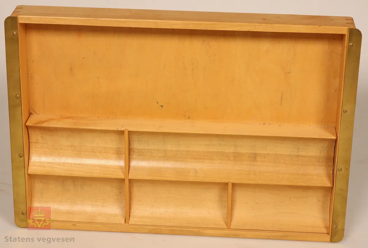 Sort solid tapeholder av metall. Sitter i en taperull av typen som må fuktes for å lime. Er merket med Kvikk II, Rasch&Co a/s- OSLO- Postboks 96. 
Mål: B 10cm, H 10cm, L 32cm.

Kart-måler av metall og glass, ligner på et lommeur med tallskive. Den har et lite hjul i enden som dras over kart for å måle avstander. Merket HC: (Harbo Colbjørnsen).
Mål: B 3cm, L 7cm,  Tykkelse 0,7cm, Diameter på glass Ø 3cm.

Bokstøtte av sortlakket metall med gull dekor.
Mål: B 13cm, H 14cm, D 15cm Tykkelse 0.1 cm.

Pengekasse av grønnlakkert metall med inndeling for sedler og mynter. 
Mål: B 30cm, D 18cm, H 4cm.

Skriveunderlag av metall med påsydd forsterkning av skinn  i hjørner. Beregnet for bruk i felt.
Mål: H 40cm, B 30cm, Tykkelse 2mm.

Skuffesorterer av lakkert lyst treverk med inndeling for sortering av småting som binders.
Mål B 33cm, D 23cm, H 3,5cm.

Tape-pen av gullfarget metall med 1/16" tape. Det er inngravert: Planavd. Sort etui med lokk og bruksanvisning inne i lokk. Er merket med Chart-pak,  Leeds, Massahusetts. 
Mål etui: L 14cm, B 9cm, H 4cm. Mål tape-pen: Diameter 7cm, Tykkelse 6mm.

Skriveunderlag av hvit papp som er forsterket i kanter og hjørner med brunt skinn. Har flekker av blekk.
Mål: H 43cm, B 62cm, Tykkelse 2mm.

Rundt lodd av metall med spiss i enden. For loddesnor.
Mål: L 8cm, Diameter 3cm.


