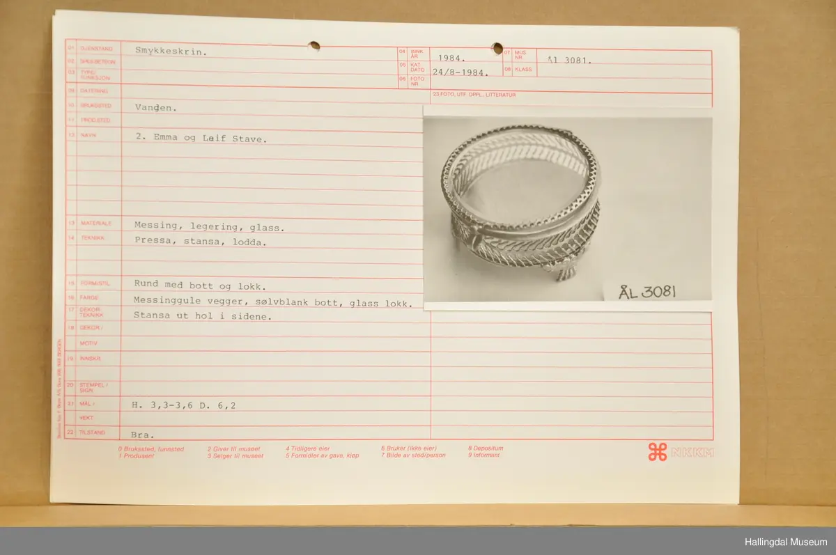 Smykkeskrin med messinggule vegger, sølvblank bott, glaslokk, stansa ut hol i sidene.